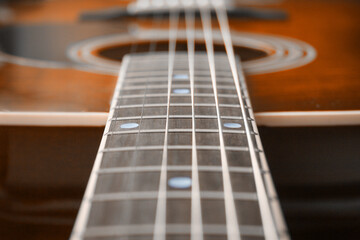 Neck a wooden acoustic guitar (closeup, with shallow depth of field)
