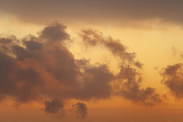 Obraz na płótnie Canvas Dramatic view of a dark silhouettes of clouds in the orange sky