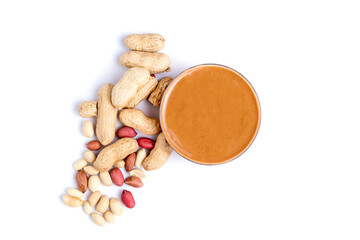 Peanut butter isolated and peanuts in the peel scattered on the white background. Copy space.
