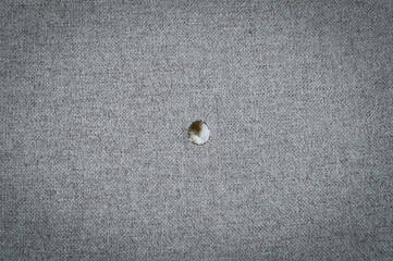 Cotton fabric with a hole from a cigarette