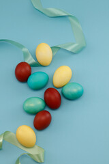 Colorful Easter eggs with green ribbon on blue background