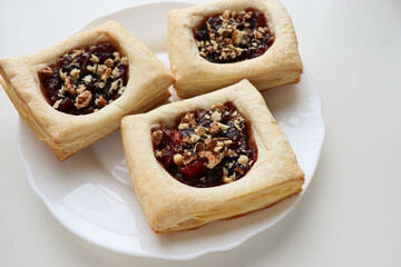 puff with jam and nuts on a wooden table. frozen pastry. 