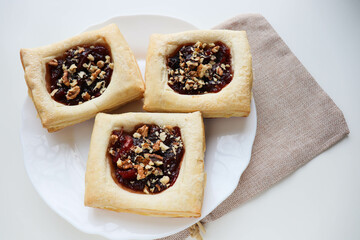puff with jam and nuts on a wooden table. frozen pastry. 