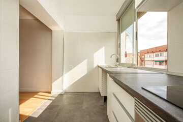 Semi-furnished studio with white kitchen cabinets, gray stone countertops, and mixed-material flooring