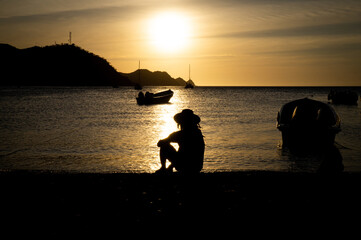 Fototapeta premium Silhouette of man with hat looking at the horizon