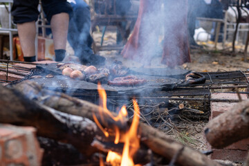 barbecue with sausage, meat, chicken, onions, pepper, chistorra, ham and pork shared with friends into the woods