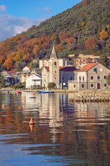 Fototapeta na wymiar Beautiful winter Mediterranean landscape. Montenegro, Adriatic Sea. View of Bay of Kotor and Donja Lastva village ( Tivat ). Catholic Church of Saint Roch ( St Roko )