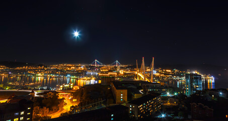 Fototapeta na wymiar Panorama of Vladivostok at night with the Golden Bridge and the bridge Russian. Far East, Russia