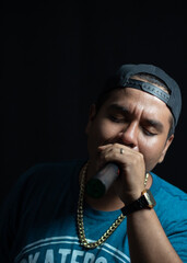 latin urban artist, rapper singing with passion, using a microphone
