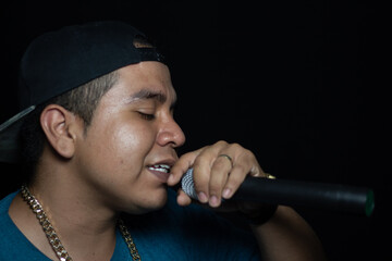 latin urban singer singing and handholding a microphone