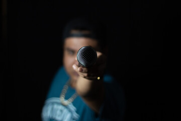 point of view of a microphone held by a singer's hand, singer showing the microphone to the camera - obrazy, fototapety, plakaty
