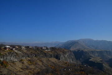 Panoramic view of the mountains and small residential buildings with white roofs.