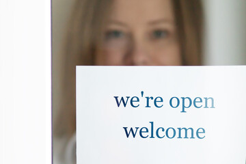 we're open,owner of the beauty salon at the door entrance opens his small business again after the coronavirus pandemic