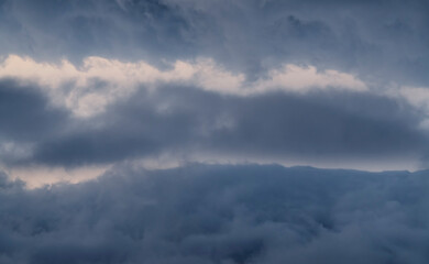 Fantastic fluffy clouds in the sunset sky. 
Sky background.