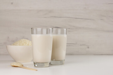 Dairy free rice milk in glasses and seeds in a bowl. Trendy beverage