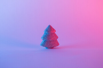 Decorative Christmas tree  on iridescent neon background. Minimal concept.