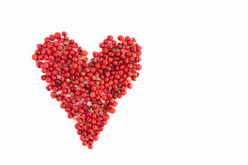 Isolated pink pepper in the shape of a heart on a white background, love of cooking