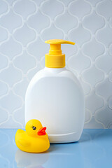 Soap or shampoo white bottles with cute duck  in the bathroom. Baby bathing accessories