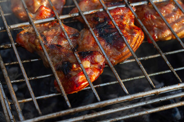 pork ribs in tomato honey sauce on an old grill in the garden. There is a concept on the street,healthy cooking of barbecue meat