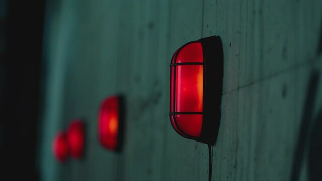 Many warning alert blinking lamps and danger attention sign on the concrete wall . Signalization , alarm , safety , security concept . Close up Shot on ARRI ALEXA Cinema Camera in Slow Motion .