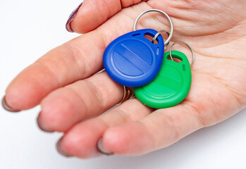 Plastic electronic keys for intercom  on the woman's hand. Radio frequency identification door lock.