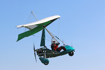 Ultralight airplane flying in a blue sky	