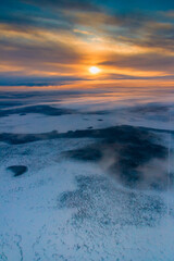 Naklejka na ściany i meble Aerial view of winter snowy countryside at sunrise