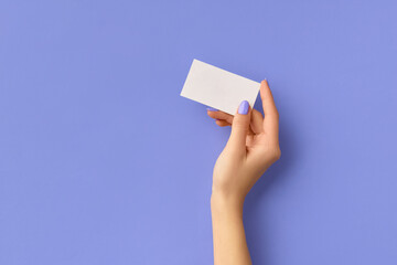 Womans hand holding business card on purple background. Business work template mockup