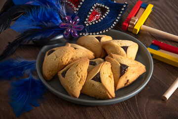Traditional jewish sweets hamantaschen cookies in a blue vintage plate on a wooden background,...