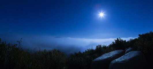 Moon and Blanket of Clouds Over the Mountains on Cold Night