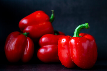 Red Paprika isolated on black. Minimalistic sweet bell pepper composition on black background. Gogosari peppers, a sweet Romanian ribbed heirloom (Capsicum annuum fruit). Whole ripe pods.