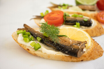 sprats in a can, fresh dill on wooden background