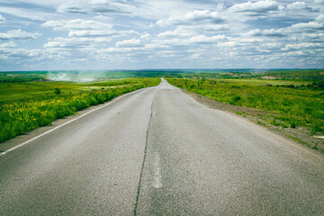 highway in the steppe against the blue sky, a long road stretched into the distance