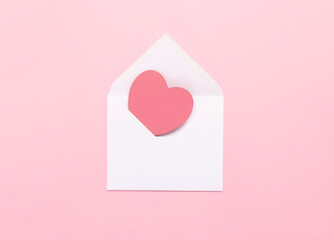 A white envelope with a large pink heart on a pink background. A love letter with a heart. Congratulations on Valentine's Day, mother's Day, Women's Day, love letter.