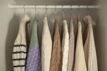 Warm beige wool pullover and knitwear and hanging in wardrobe