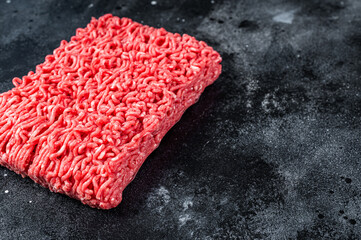 Raw mince beef meat on a kitchen table. Black background. Top view. Copy space