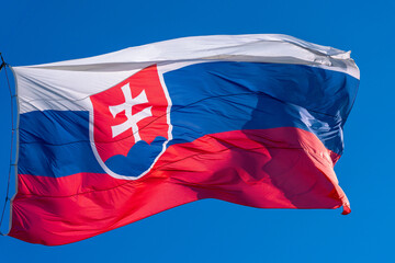Slovak national flag, large flag of Slovakia in high resolution flown against blue sky