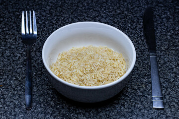 Rice bowl on a kitchen top table with cutlery