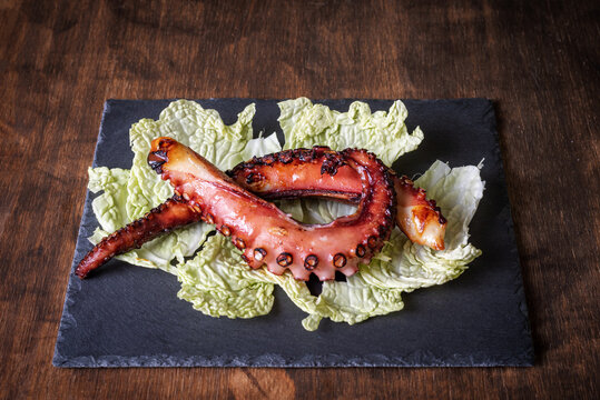 Dry octopus leg, dried according to tradition, served on a bed of cabbage on a stone plate. Typical dish of the tropical coast of Granada.