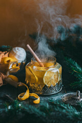 Autumn or winter hot tea with lemon and sugar with steam above the cup on a dark background
