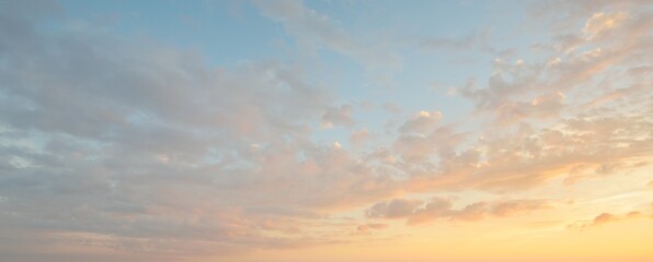 Clear blue sky. glowing pink and golden cirrus and cumulus clouds after storm, soft sunlight. Dramatic sunset cloudscape. Meteorology, heaven, peace, graphic resources, picturesque panoramic scenery