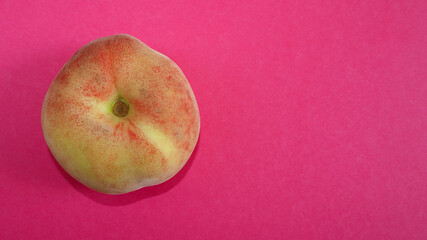 close up lies a fig peach on a pink background