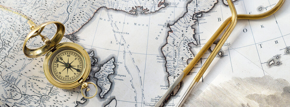 Retro styled golden compass (sundial), antique vintage W & HC 6" brass dividers calipers nautical navigation chart tool and old white map close-up. Vintage still life. Sailing accessories