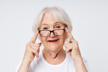 Portrait of an old friendly woman vision problems with glasses light background