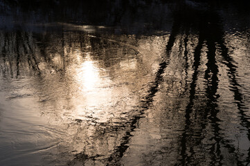 The flow of the river in the reflection of the morning light of the sun in calm waves. Background