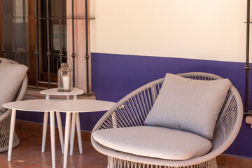 Terraza con sillon gris y mesa con lámpara exterior 