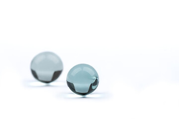 Two glass balls on a white background with space for text, the far ball is blurred.