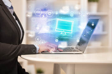 Hands working on laptop with digital icons