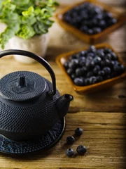 Foto op Aluminium Vintage composition in retro style. Beautiful teapot in the foreground, fresh blueberries in bowls, indoor flower. Wooden texture. Breakfast, healthy foods, vitamins, antioxidants. © Anton