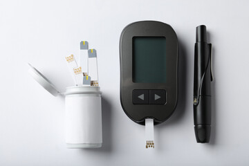 Digital glucometer, lancet pen and test strips on white background, flat lay. Diabetes control - obrazy, fototapety, plakaty